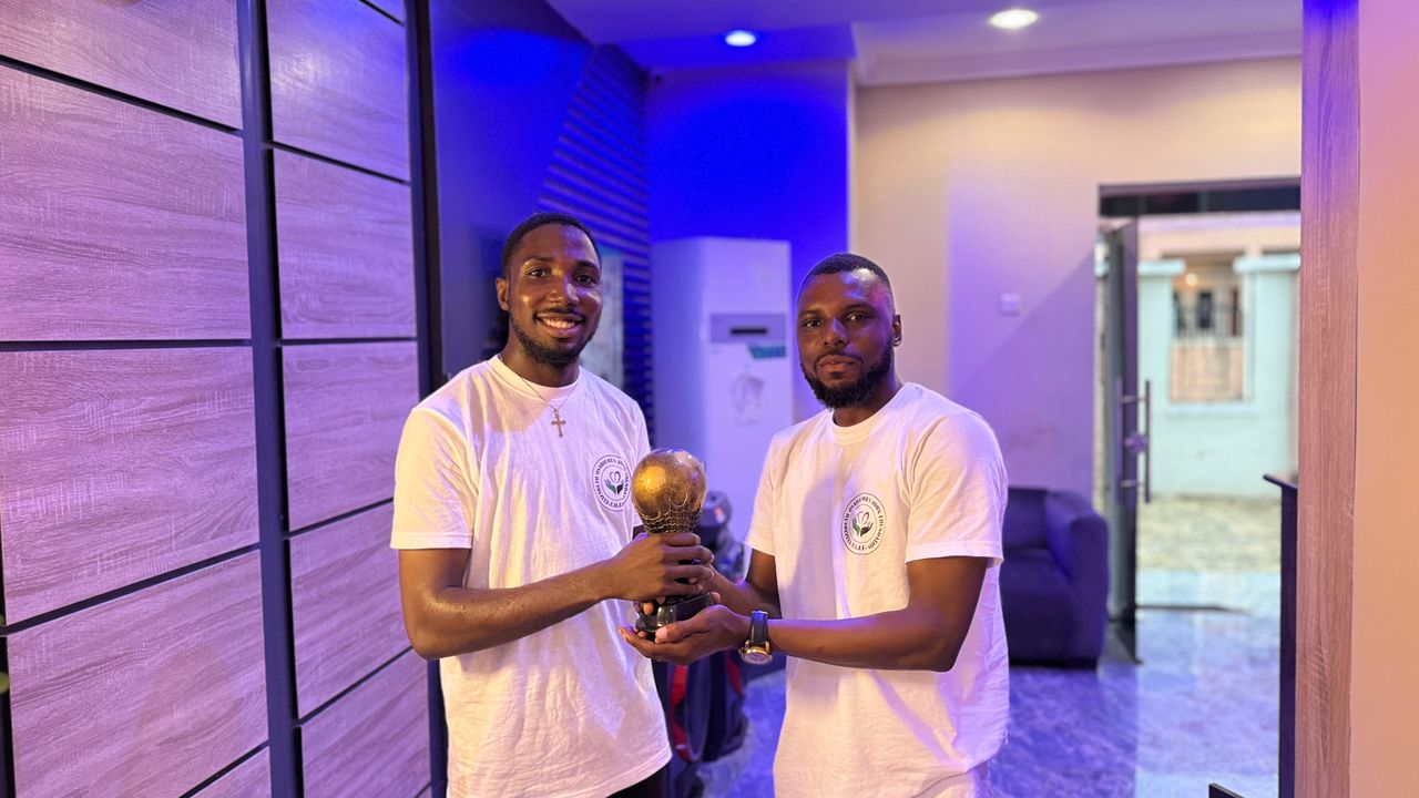 Group of foundation members with provisions for aid distribution indoors - ELIZABETH OSARIEMEN JOHN FOUNDATION making impact in Nigerian communities